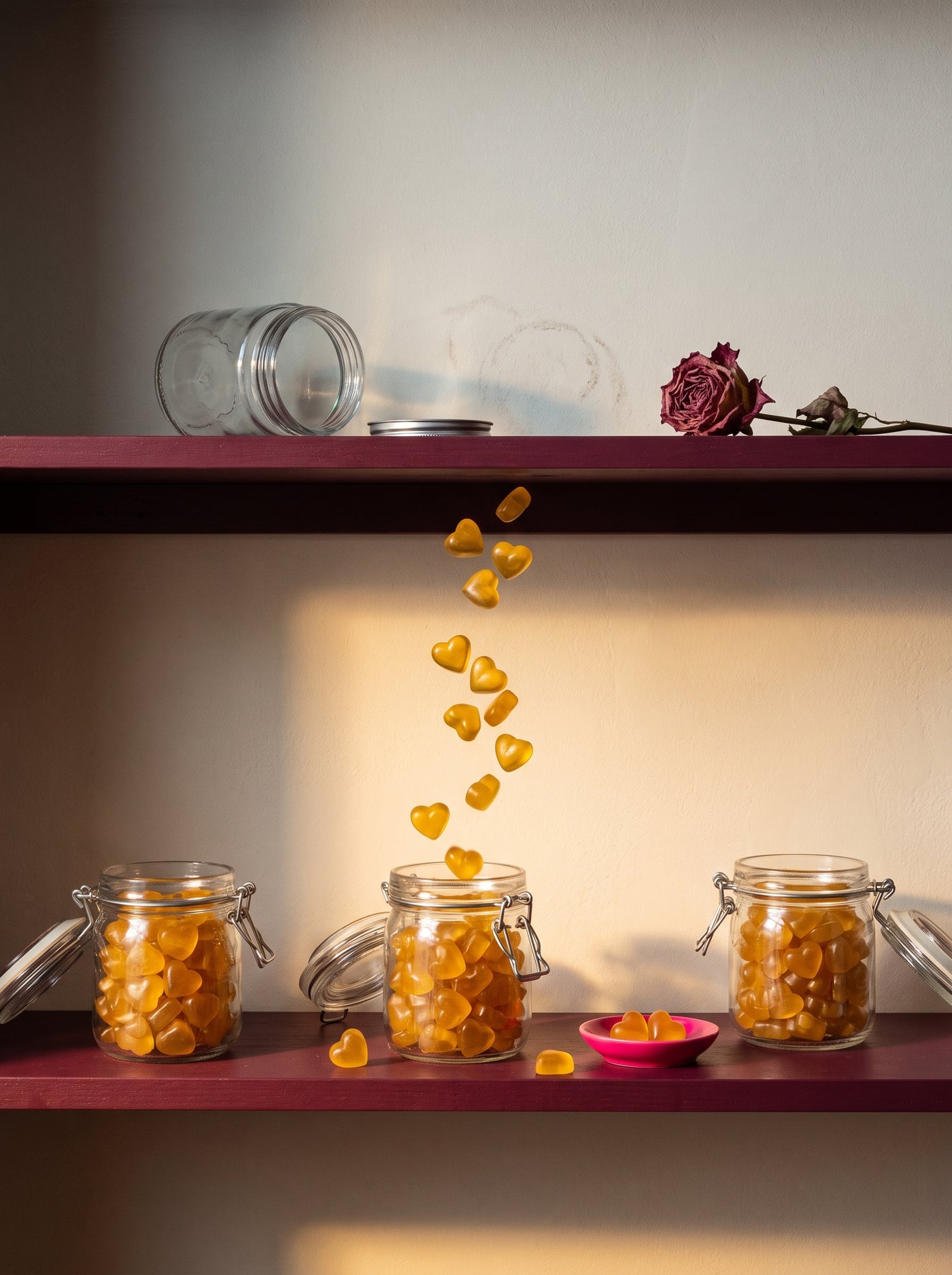 an emptied pantry shelf being restocked with jars of golden heart gummies